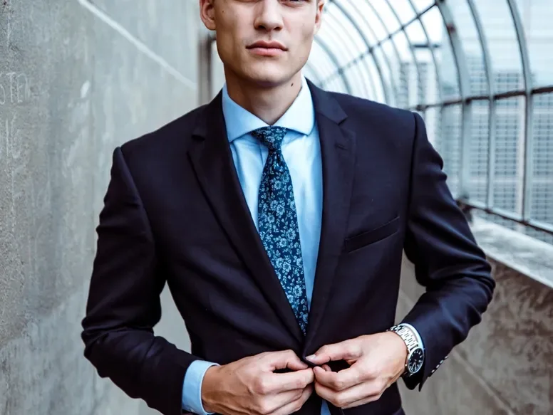Man buttoning a navy suit jacket