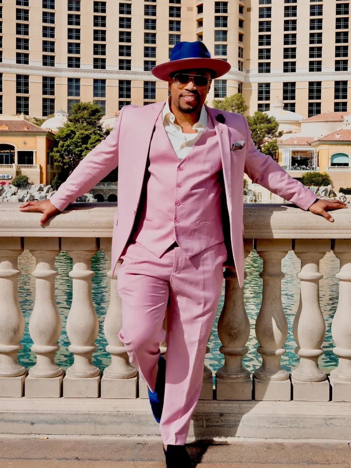 Customer in a pink three-piece suit and fedora at the Bellagio fountains