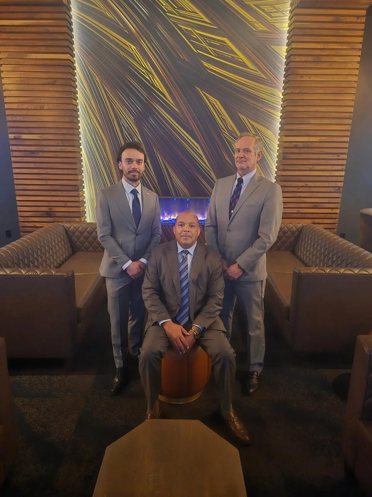 Three men in tailored suits from Jacobi's at a lounge